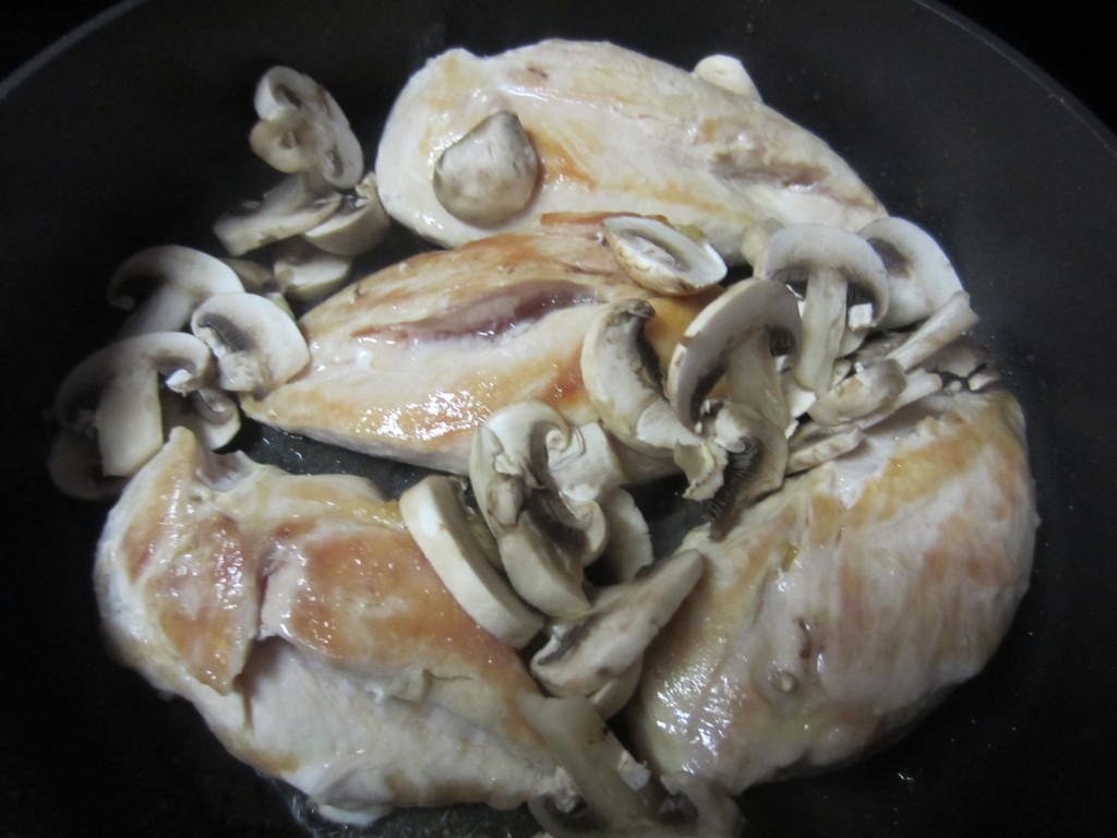 Add mushrooms to chicken in skillet