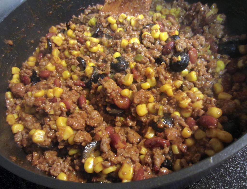 adding ingredients to chili